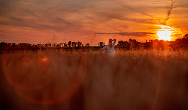 istock Woman in wheat field at sunset 1357000703