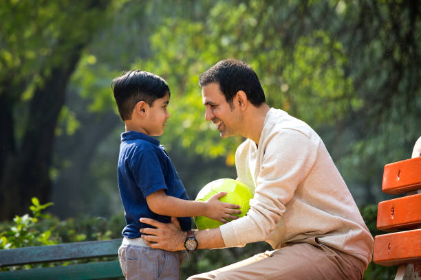 istock Carefree father and son having fun at park 1357003987