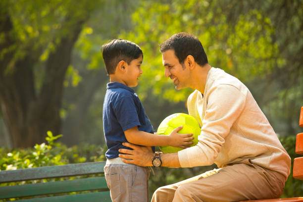 istock Carefree father and son having fun at park 1357004019