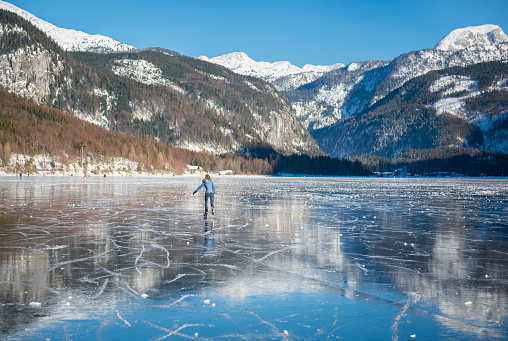 Beautiful woman Ice Skating on the Frozen Lake Grundlsee, Austria