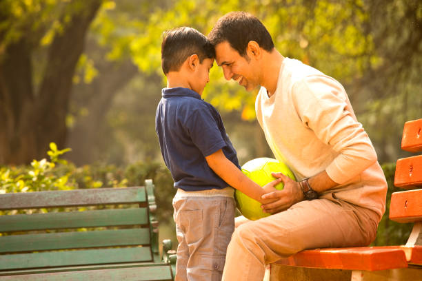 istock Carefree father and son having fun at park 1357005390