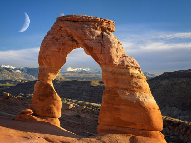 delicate arch in Arches National Park with clouds and moon delicate arch in Arches National Park with clouds and moon delicate arch stock pictures, royalty-free photos & images