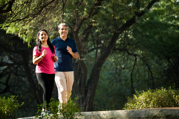 couple jogging at park - asian ethnicity jogging female women imagens e fotografias de stock