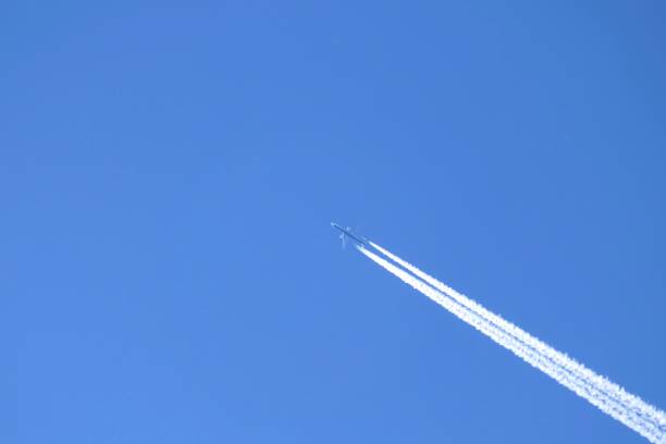Low angle view to the sky of an airplane with contrails