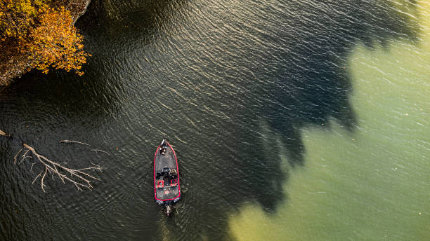 Bass Fisherman fishing lake during fall bass fisherman fishing out of bass boat in the fall. Drone photo taken from above on grand lake in oklahoma freshwater bass stock pictures, royalty-free photos & images