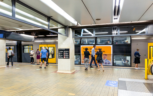 Sydney, Australia - May 13, 2021: Train arriving in Martin Place subway train station with waiting passengers
