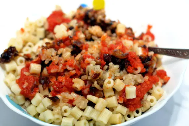 Photo of Egyptian cuisine, Koshary the national dish of Egypt and popular street food made of rice, macaroni, and lentils mixed together topped with a spiced tomato sauce