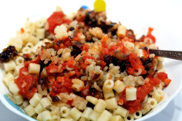 Photo of Egyptian cuisine, Koshary the national dish of Egypt and popular street food made of rice, macaroni, and lentils mixed together topped with a spiced tomato sauce