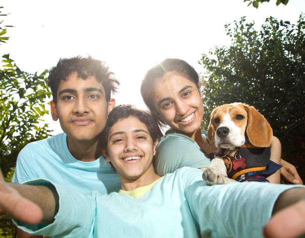 istock Teenagers with pet dog talking selfie 1357018678