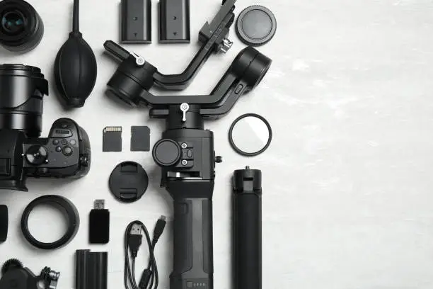 Photo of Camera and video production equipment on light background, flat lay. Space for text