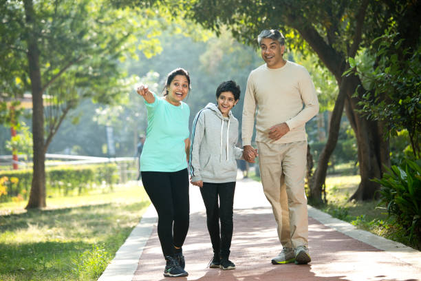 istock Happy family walking at park 1357020442
