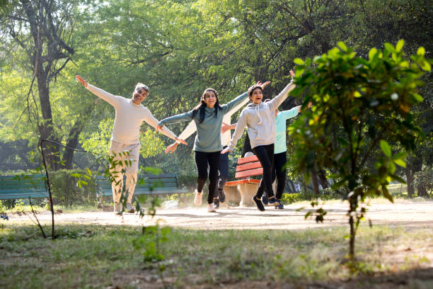 Carefree Indian family having fun together while walking with arms outstretched at park