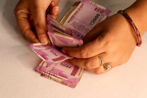 Hands counting new 500 Indian Rupee banknotes. Finance, wealth, and savings concept.