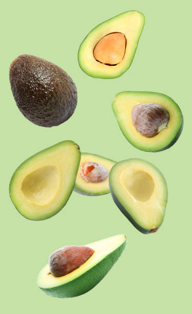 istock Fresh ripe avocados falling on light green background 1357022954