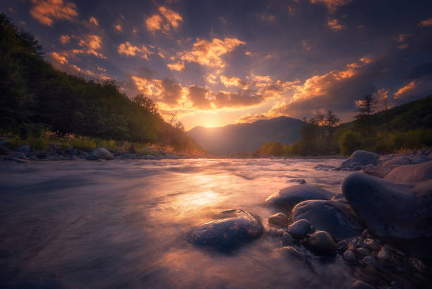 Beautiful sunset over fast flowing mountain river.