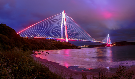 Yavuz Sultan Selim Bridge in evening illumination. Suspension bridges in İstanbul, Turkey. Long exposure, Violet, purple cloudy sky Background.
