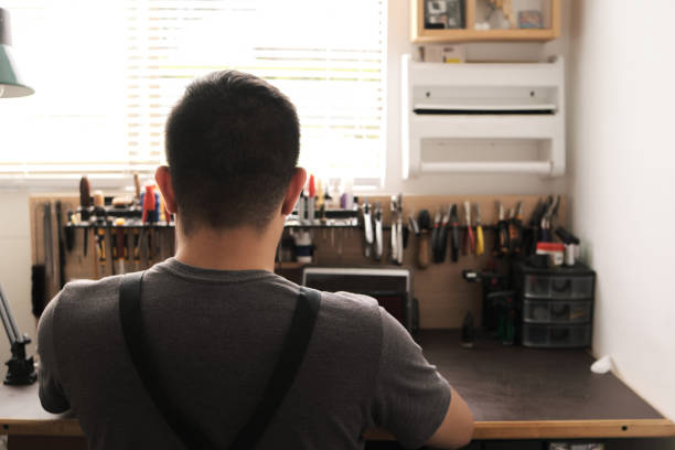 istock instrument repairman seen from behind working at his workbench 1357036256