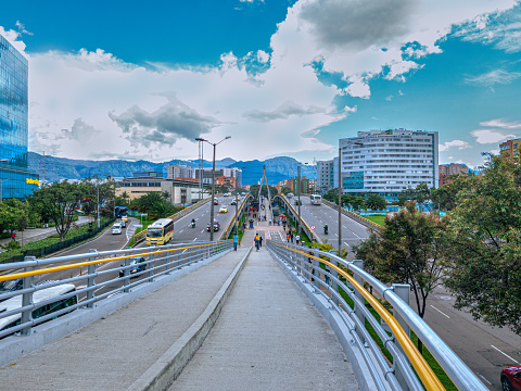 Bogota, Colombia - A high angle view of the bridges on Avenida Esperanza, also called Calle 24 or Avenida Luis Carlos Galán, at the point where the Avenida Esperanza goes over Avenida 68. Between the two West and Eastbound bridges is the footbridge combined with bicycle lanes. In the far background are the Andes Mountains. The altitude at street level is 8,660 feet above mean sea level. Image shot on mobile phone, on a fairly clear day with blue skies and white clouds.