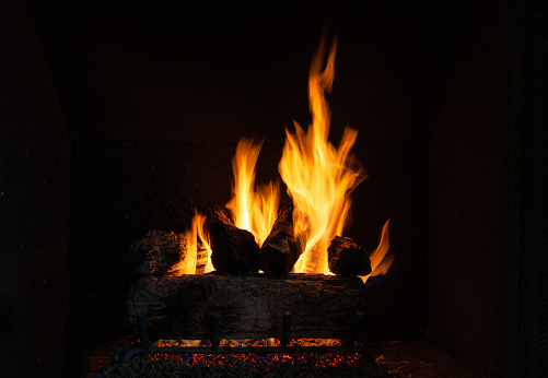 Firewood burning in fire. Flame in furnace. Hearth in house. Fireplace details. Yellow light.