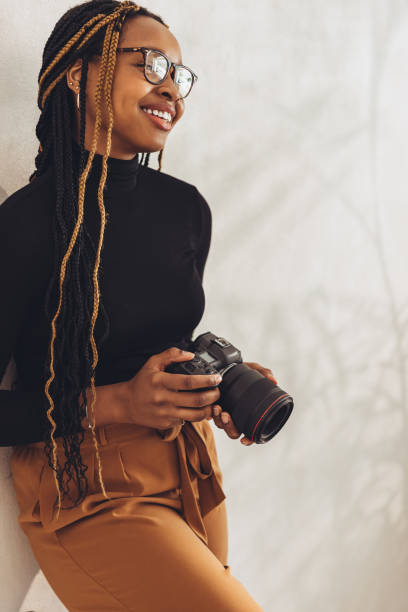 istock Young photographer standing against a wall 1357040203