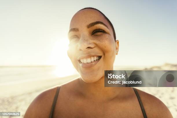 Carefree young woman smiling at the beach
