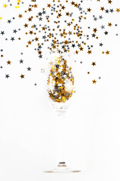 istock Simple minimalistic Christmas home decor.Flat lay,top view.Christmas background.Festive composition of a glass of champagne and glitter on a light background.Copy space. 1357044190