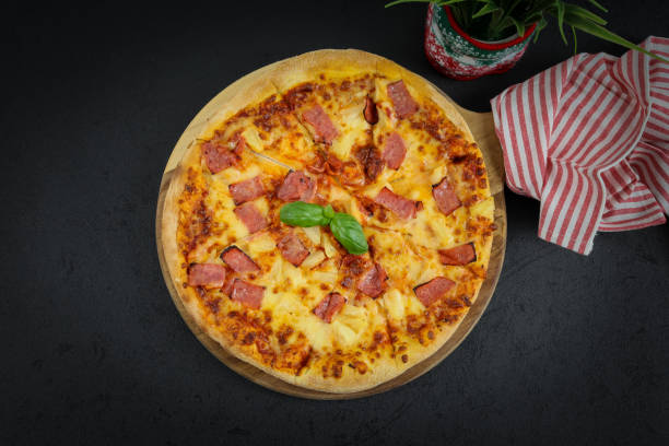 istock Round baked pizza on a wooden cutting board 1357049039