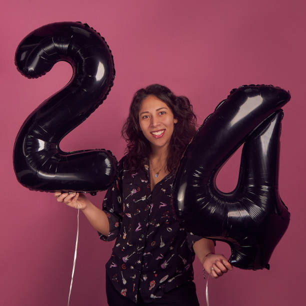istock Latin woman smiling studio black balloons twenty four 1357050927