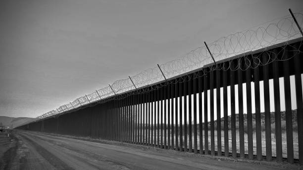 mexico international border wall - diminishing perspective looking through the bars of the u.s customs and border patrol border wall located in jacumba, california - usa international border stock pictures, royalty-free photos & images