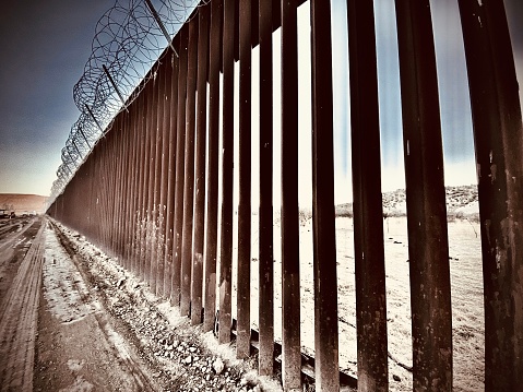 looking through the bars of the u.s customs and border patrol border wall located in jacumba, california - usa