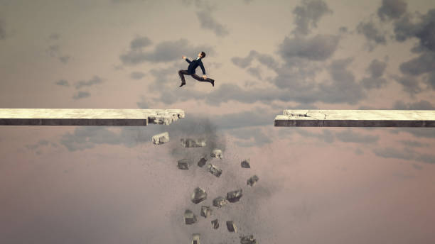 istock Businessman jumps over a falling gap of a road . Risk taking and overcoming problems . This is a 3d render illustration . 1357064021