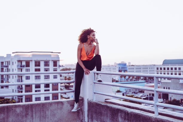 istock Contemplative young woman sitting on an urban rooftop thinking 1357065627