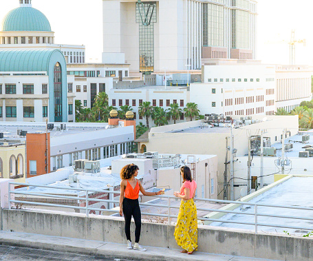 Young women relax together on urban rooftop enjoying the view and the company