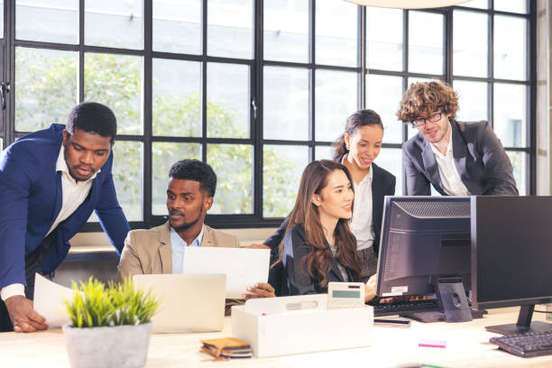 istock Colleagues in a boardroom discussion, seated at a table together, swapping ideas and strategizing project strategy. In the office, young business professionals 1357069988