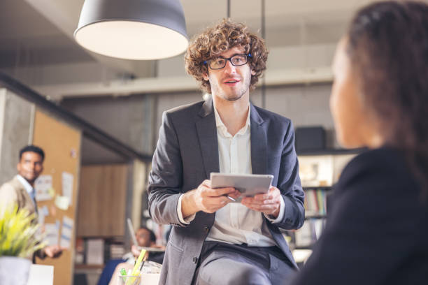istock Colleagues in a boardroom discussion, seated at a table together, swapping ideas and strategizing project strategy. In the office, young business professionals 1357070126