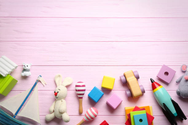istock Different toys on pink wooden background, flat lay. Space for text 1357070598