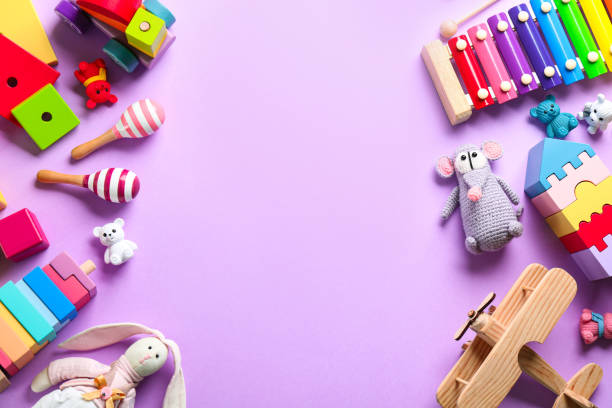 Different toys on lilac background, flat lay. Space for text