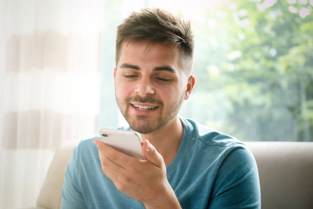 istock Young man using voice search on smartphone indoors 1357070857