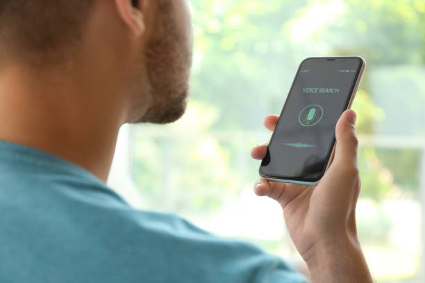 istock Young man using voice search on smartphone indoors, closeup 1357070983