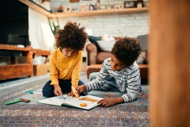 istock Creative black kids drawing while relaxing on the floor at home. 1357073725