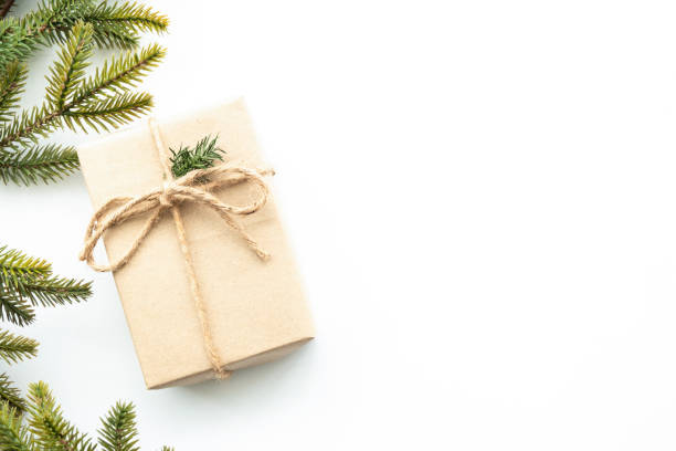 istock Beautiful Christmas background with gift box, decorate with pine branches over white background. Top view with copy space, flat lay. 1357080474