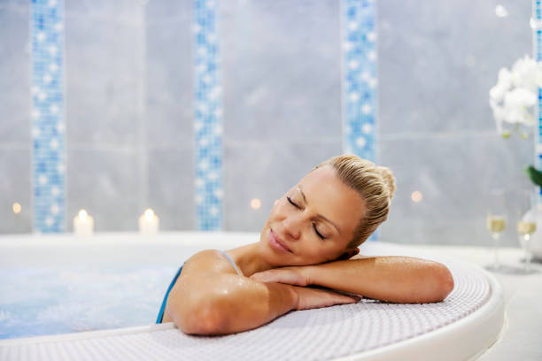 A woman relaxing in the hot tub with her eyes closed. Wellness and spa. Weekend in spa center. A woman in the hot tub. A woman relaxing in the hot tub with her eyes closed. Wellness and spa. Weekend in spa center. A woman in the hot tub. older woman eyes closed stock pictures, royalty-free photos & images