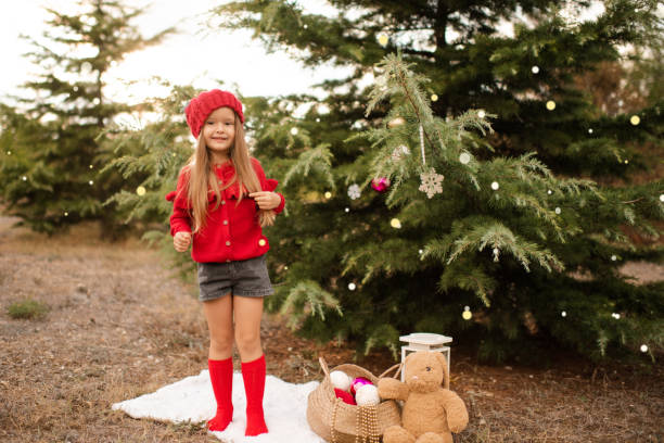 istock Kid girl decorating Christmas tree outdoors 1357085064