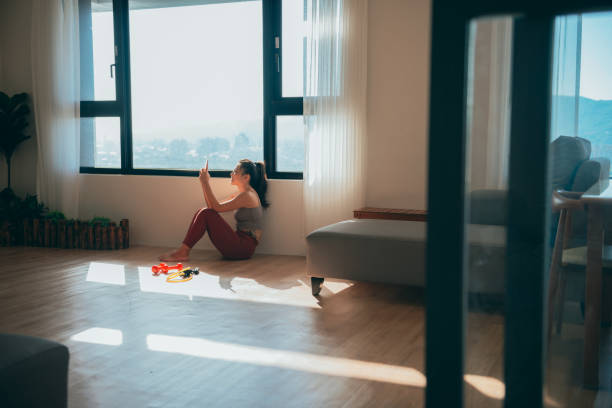 istock Woman watching the smart phone check data at the end of the workout 1357085199