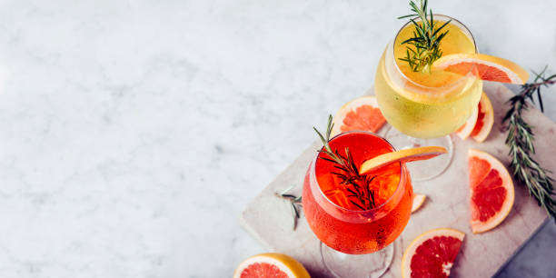 Red and white Spritz garnish in wine glasses with rosemary and grapefruit on luxury marble table. Red and white Spritz garnish in wine glasses with rosemary and grapefruit on luxury marble table. Bitter alcohol cocktail in wineglass. Top view. Happy hour restaurant menu banner. restaurant table layout stock pictures, royalty-free photos & images