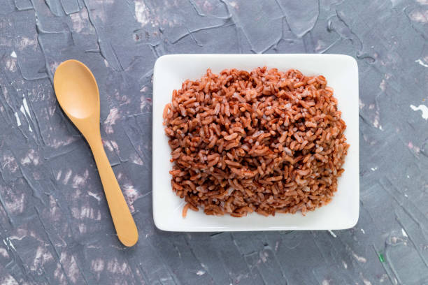 reis rot in schüssel isoliert auf grauem hintergrund. asiatisches essen gekocht. - coarse rice stock-fotos und bilder