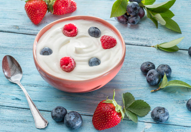 istock Ceramic bowl with plain yoghurt and berries on the table. Light summer mood. 1357089413