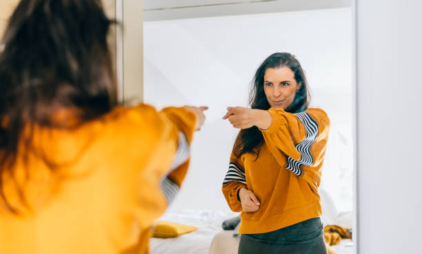 mujer soltera segura de sí misma señalando con el dedo su reflejo en el espejo, bailando y cayendo bien - desafío fotografías e imágenes de stock