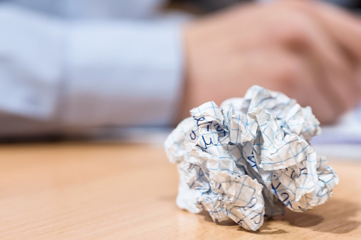 crumpled sheet of paper on a school desk on a blurred background