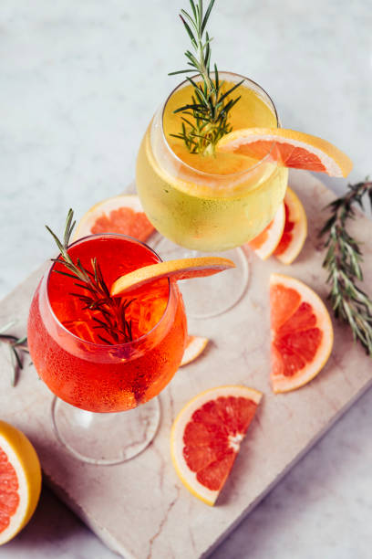 Red and white Spritz garnish in wine glasses with rosemary and grapefruit on luxury marble table. Red and white Spritz garnish in wine glasses with rosemary and grapefruit on luxury marble table. Bitter alcohol cocktail in wineglass. vodka soda top view stock pictures, royalty-free photos & images